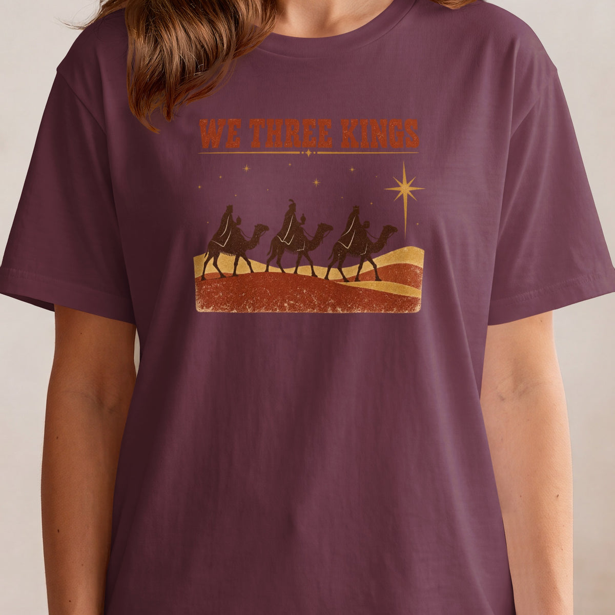 T-shirt with "WE THREE KINGS" text and a depiction of three camels and a star.