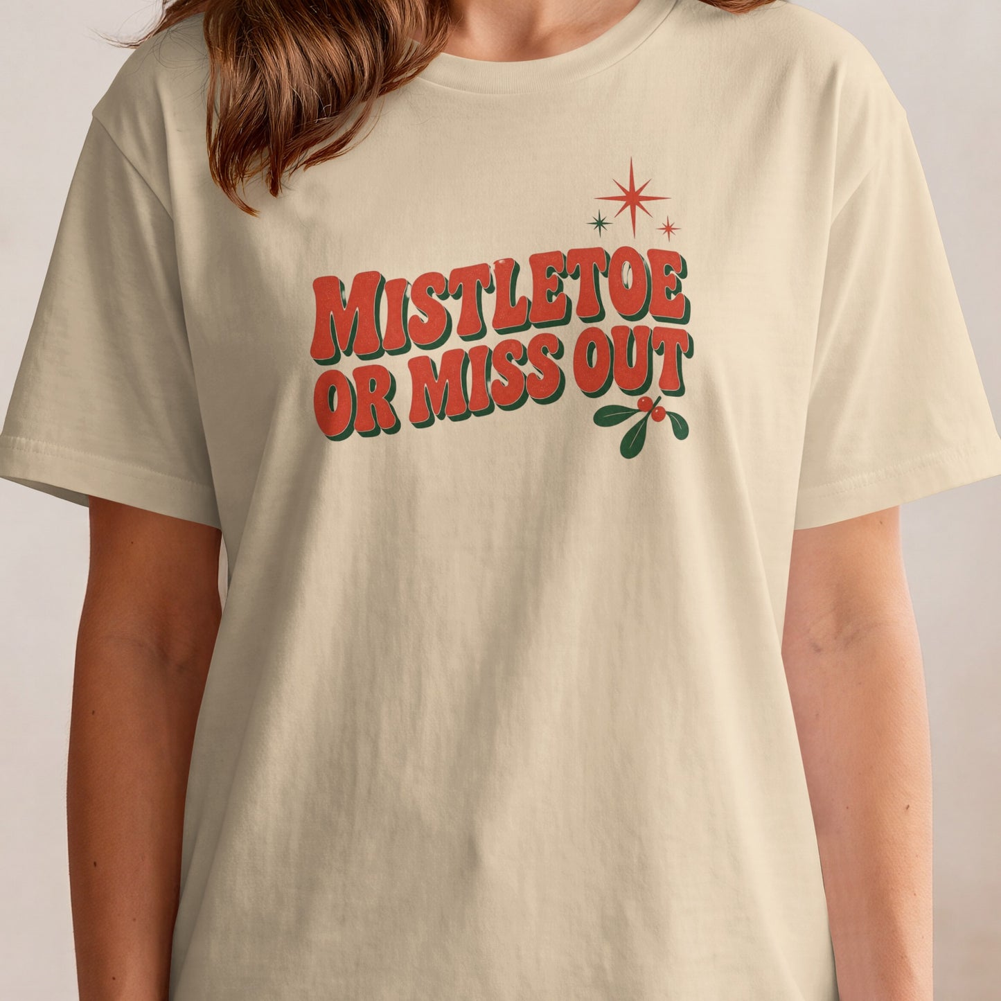 Cream t-shirt with retro text "Mistletoe Or Miss Out" and mistletoe graphic.