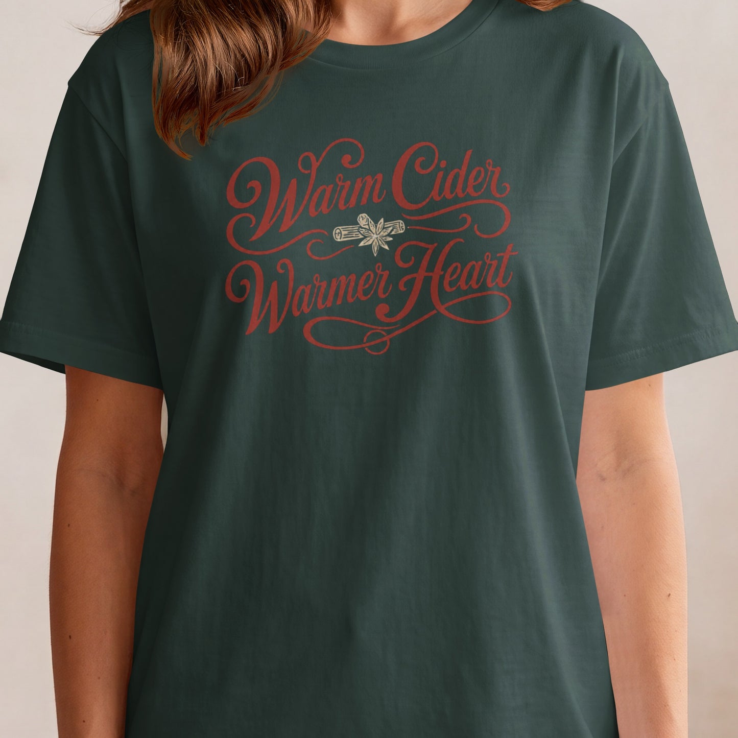 Dark green t-shirt with "Warm Cider Warmer Heart" in red script.