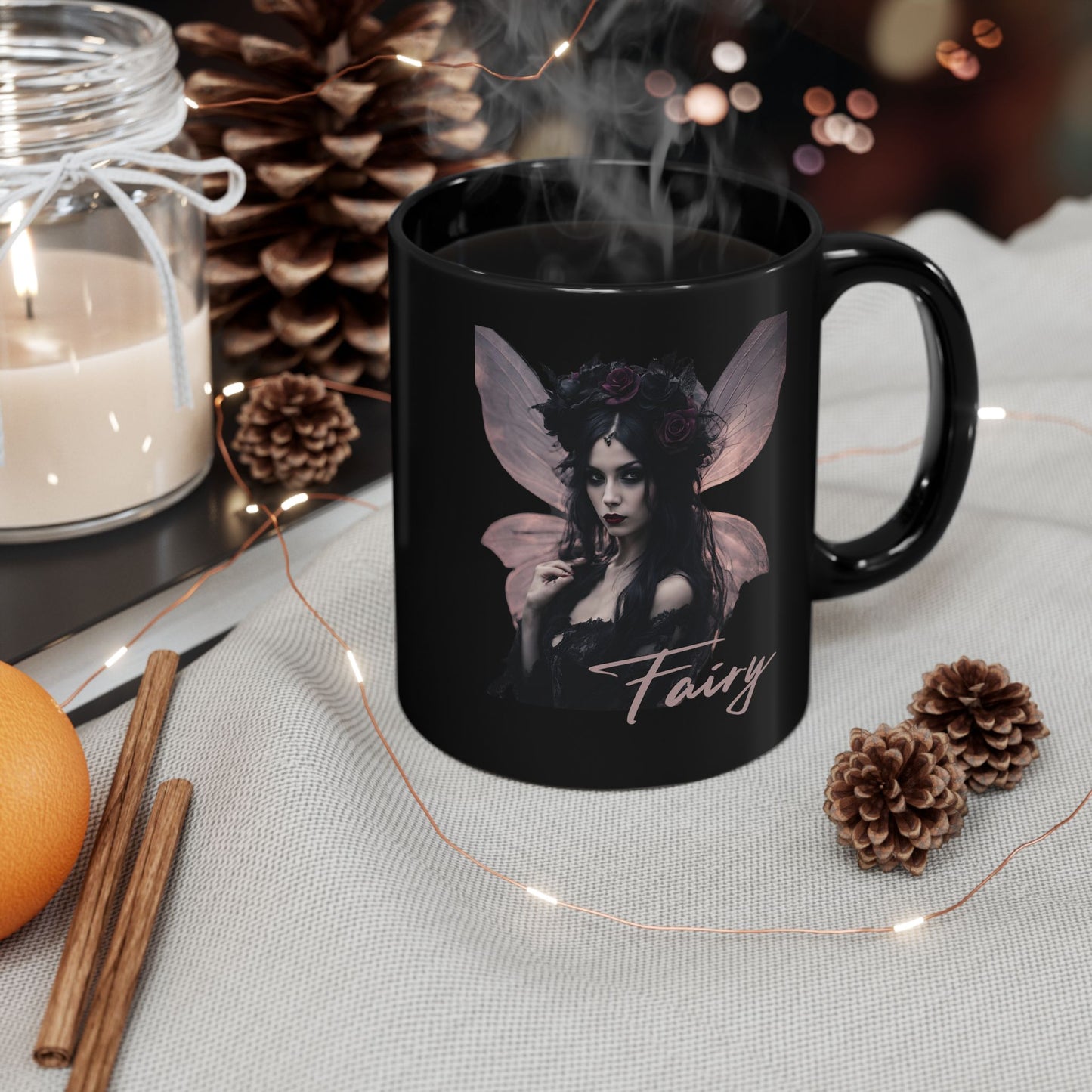 Black mug with fairy design and steam, surrounded by decorative items on a table.