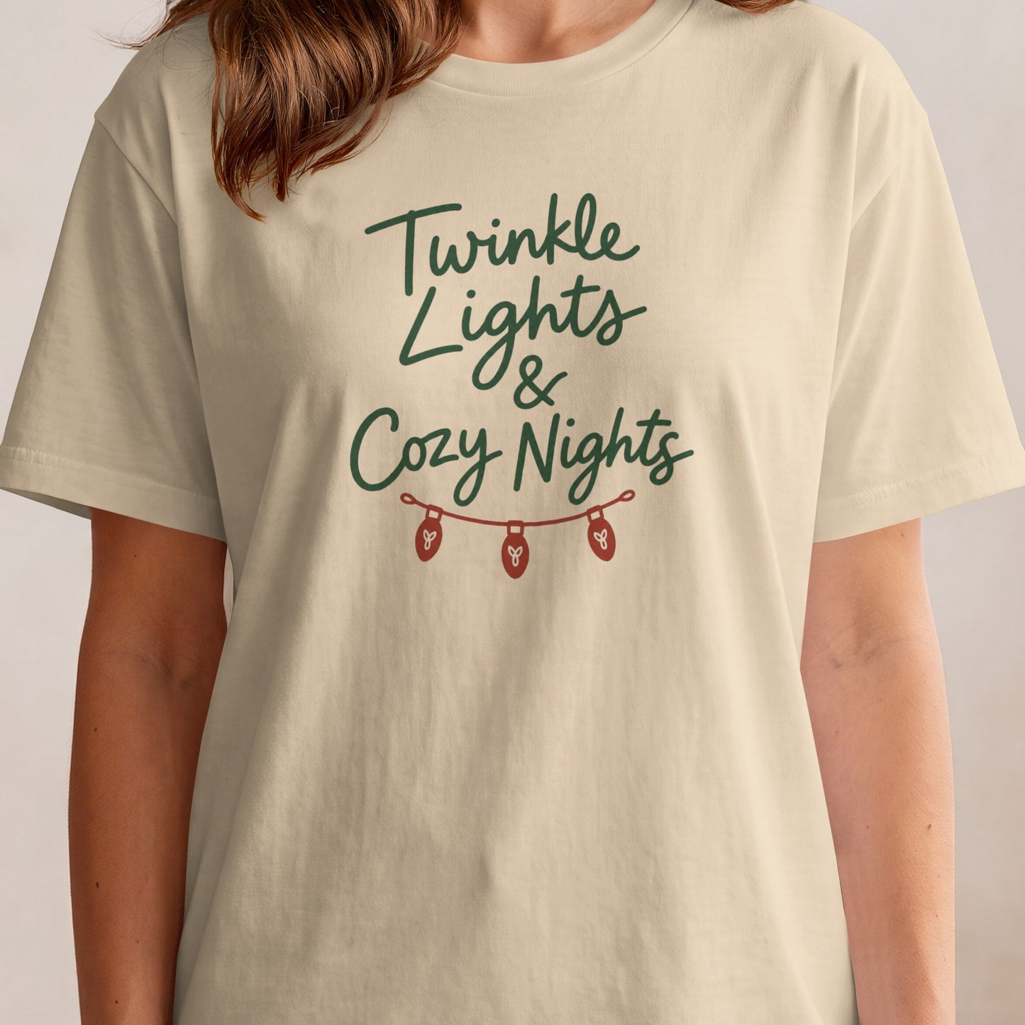 Cream t-shirt with "Twinkle Lights & Cozy Nights" text and string lights graphic.