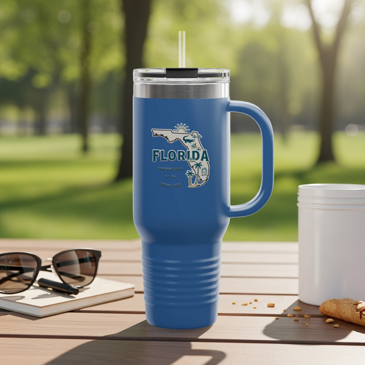 Travel tumbler with Florida Sunshine State logo, outdoors.