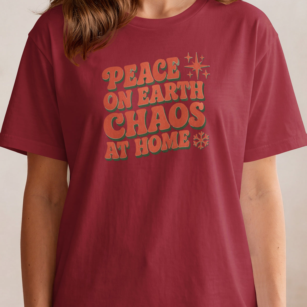 Maroon t-shirt with text "Peace on Earth Chaos at Home" and holiday graphics.