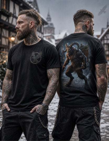 Two tattooed men standing outdoors in a snowy town setting, wearing black graphic T-shirts. The man on the left shows the front of the shirt with a circular bird emblem on the chest, and the man on the right shows the back of the shirt with a large dark fantasy creature graphic.