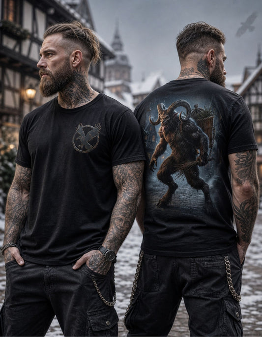 Two tattooed men standing outdoors in a snowy town setting, wearing black graphic T-shirts. The man on the left shows the front of the shirt with a circular bird emblem on the chest, and the man on the right shows the back of the shirt with a large dark fantasy creature graphic.
