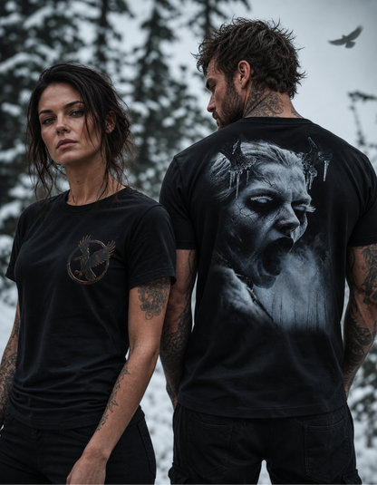 Two models wearing black graphic t-shirts in an outdoor snowy setting. The woman on the left shows the front of her black t-shirt which features a small metallic gold Mockingbird logo on the left chest.