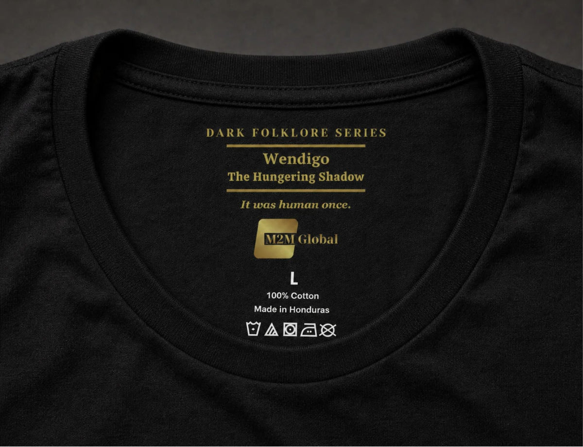 Inside neck of a black t-shirt showing the gold Dark Folklore Series label: Wendigo, The Hungering Shadow, with the original size and care label below.