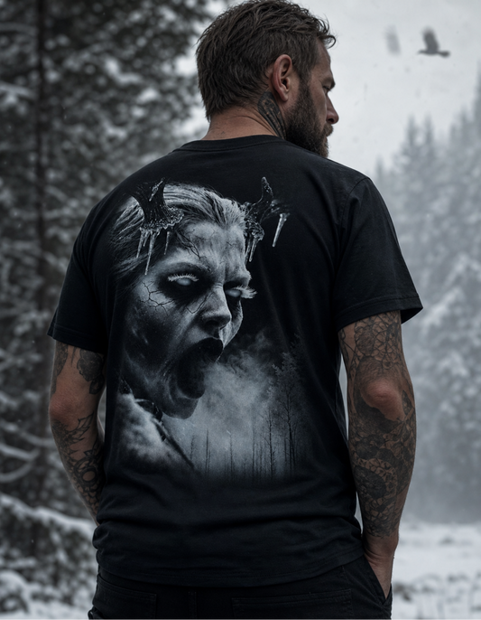 A man viewed from behind wearing a black graphic t-shirt with a large grayscale print of a screaming face on the back, set against a snowy forest background.