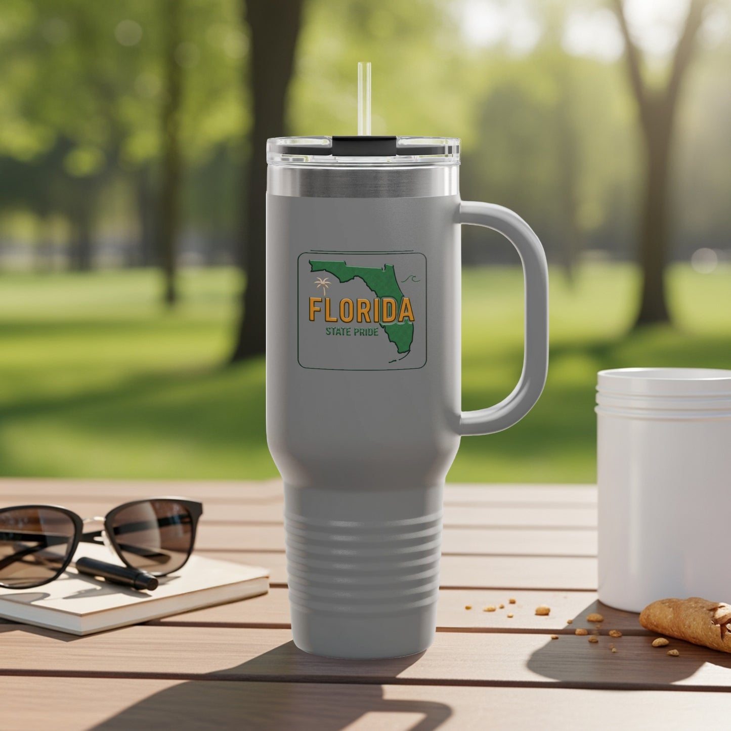 Travel tumbler with Florida Sunshine State logo, outdoors.
