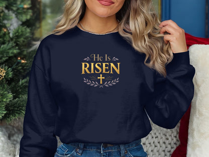 Dark blue crewneck sweatshirt with "He Is Risen" text and laurel wreath.