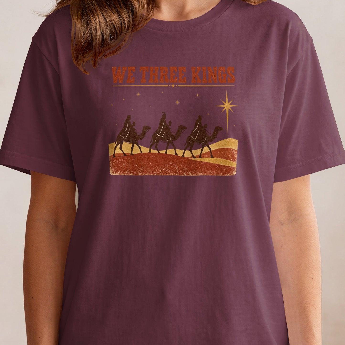 T-shirt with "WE THREE KINGS" text and a depiction of three camels and a star.