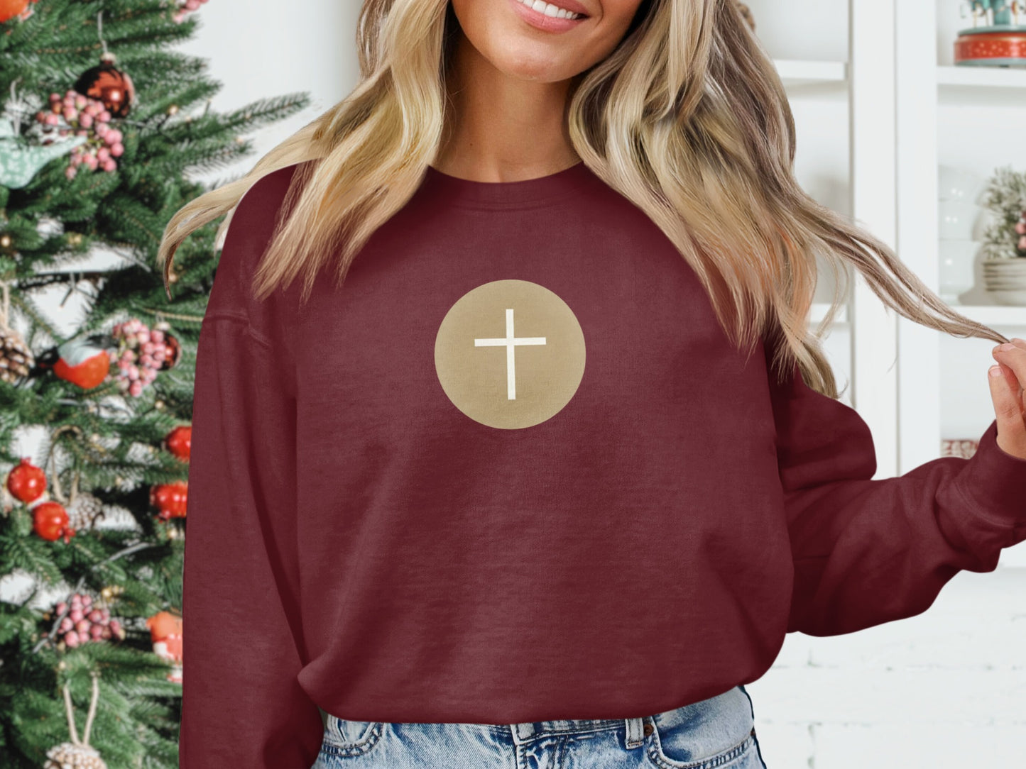 Burgundy sweatshirt with a white cross inside a gold circle on the chest.