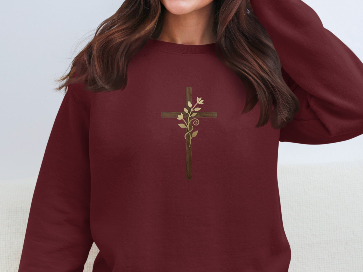 Maroon sweatshirt with a gold cross and floral vine design.