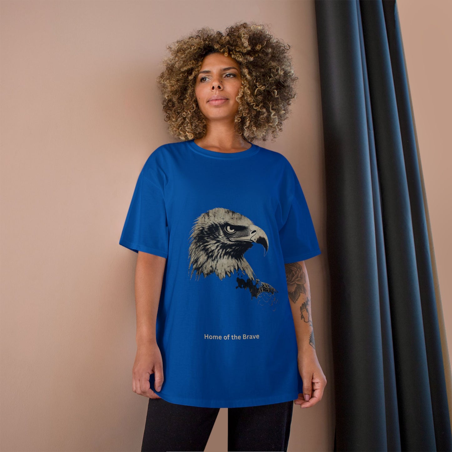 Home of the Brave small font text below an eagle head on a Champion Tee