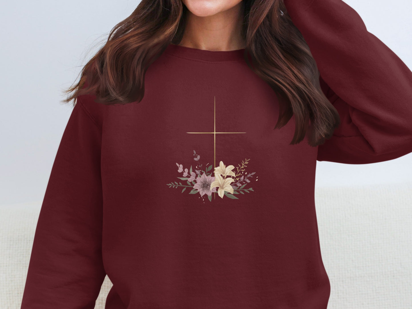 Maroon sweatshirt with a gold cross and floral bouquet graphic.