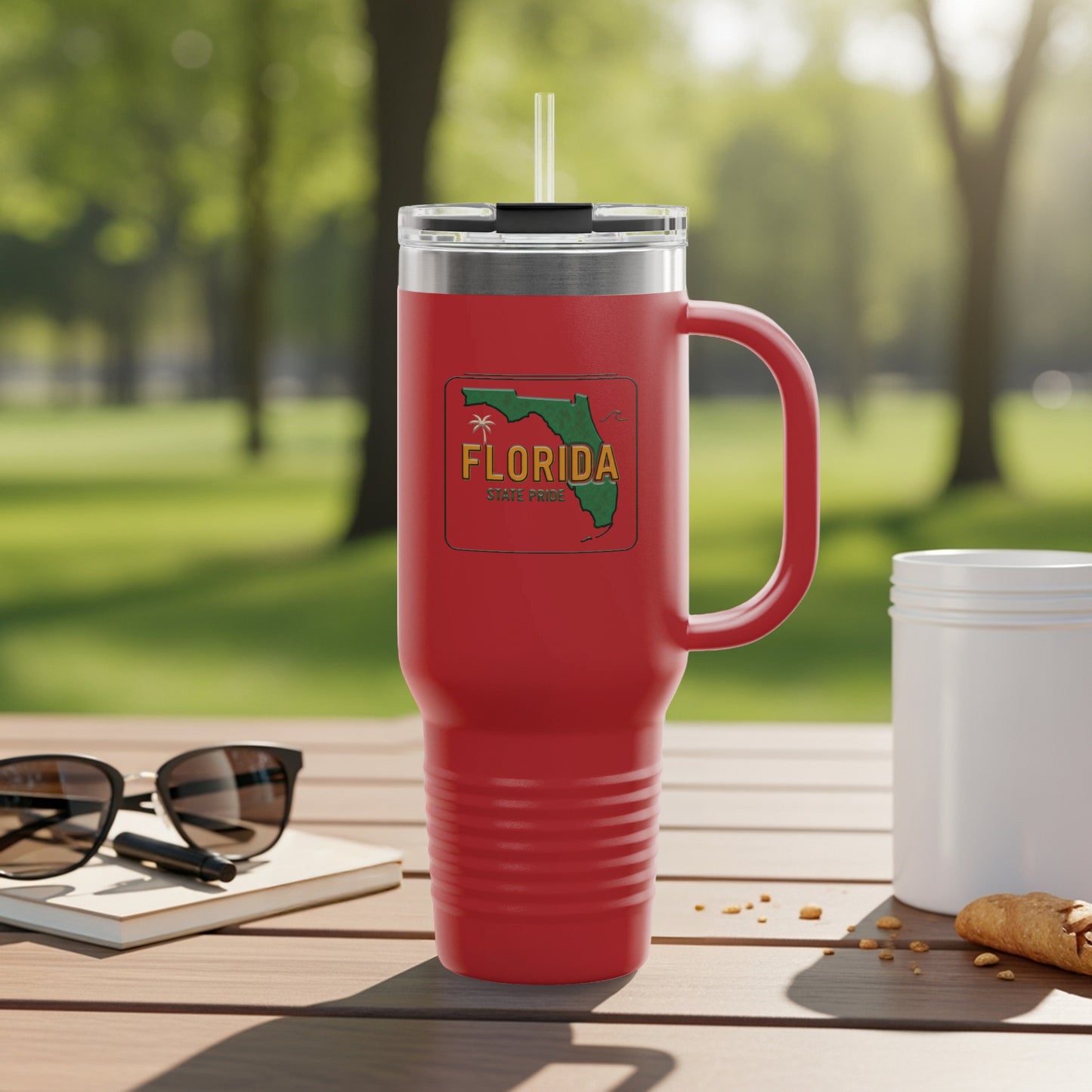 Red tumbler with Florida State Pride graphic on a wooden table.