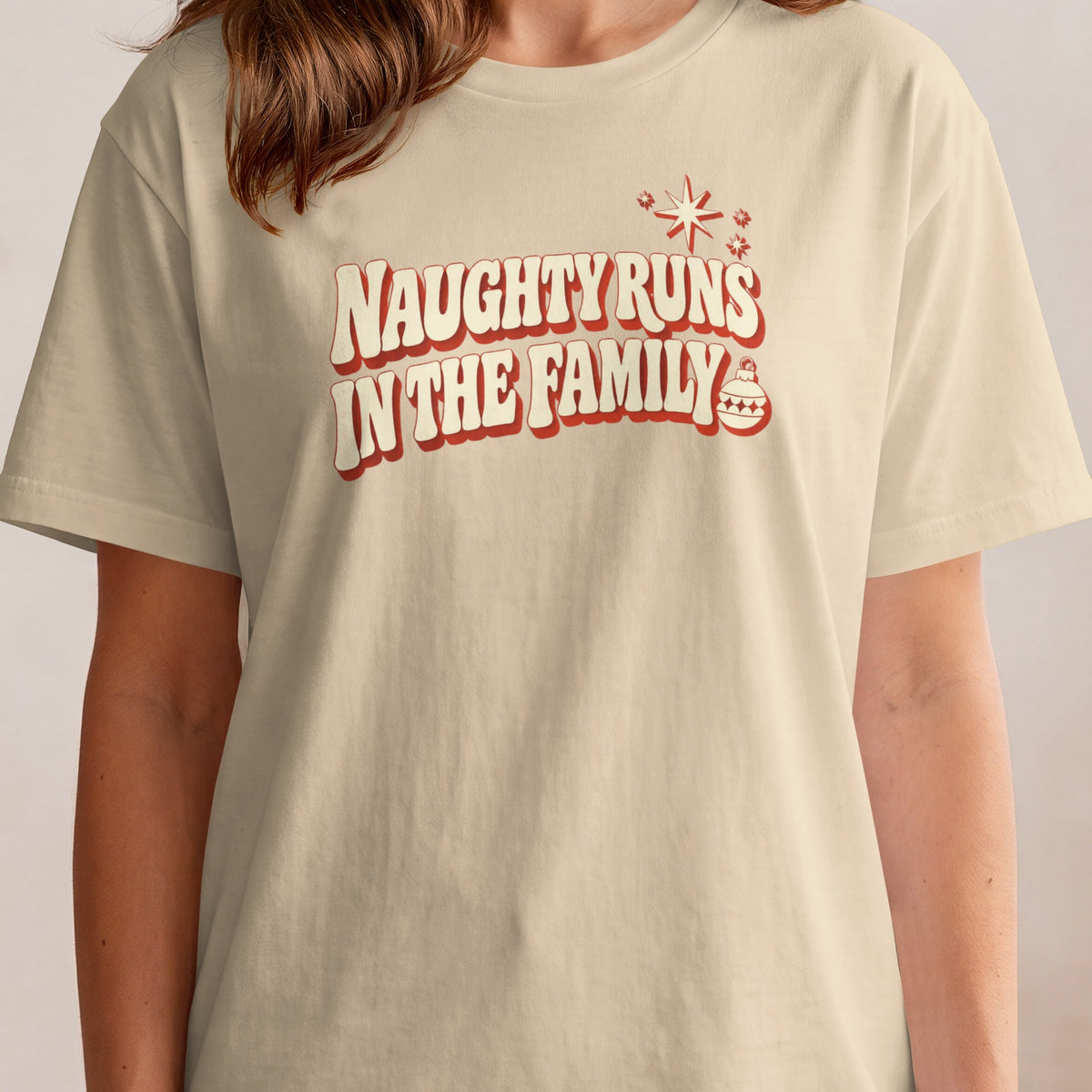 T-shirt with red and cream "Naughty Runs In The Family" text and Christmas ornaments.