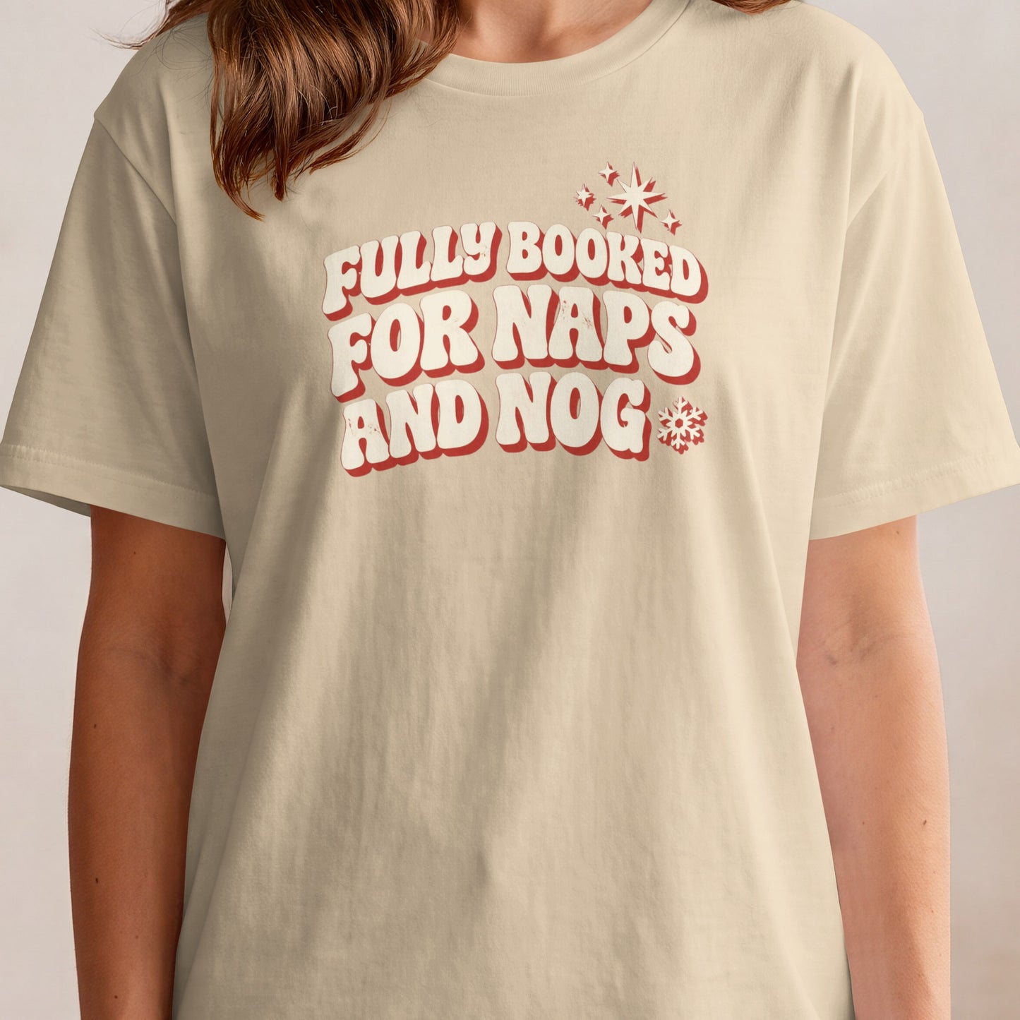 Cream t-shirt with "Fully Booked For Naps and Nog" text and snowflakes.