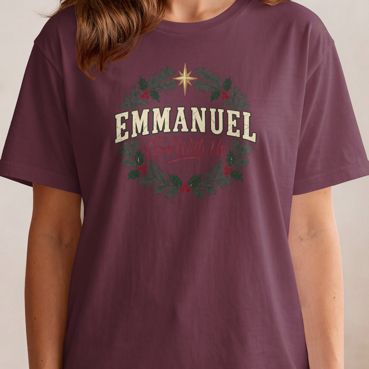 T-shirt with "Emmanuel God With Us" text on a Christmas wreath design.