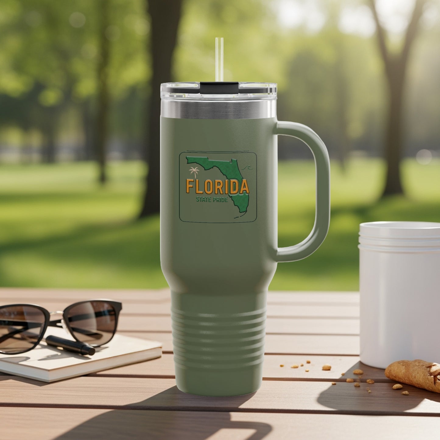 Travel tumbler with Florida Sunshine State logo, outdoors.