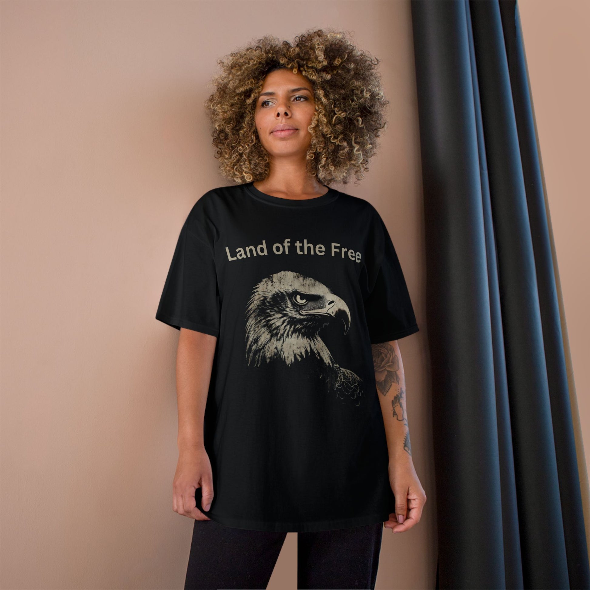 Land of the Free text above an eagle head on a Champion Tee