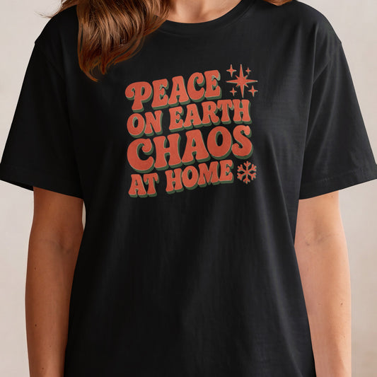 Black t-shirt with red and green text "PEACE ON EARTH CHAOS AT HOME".