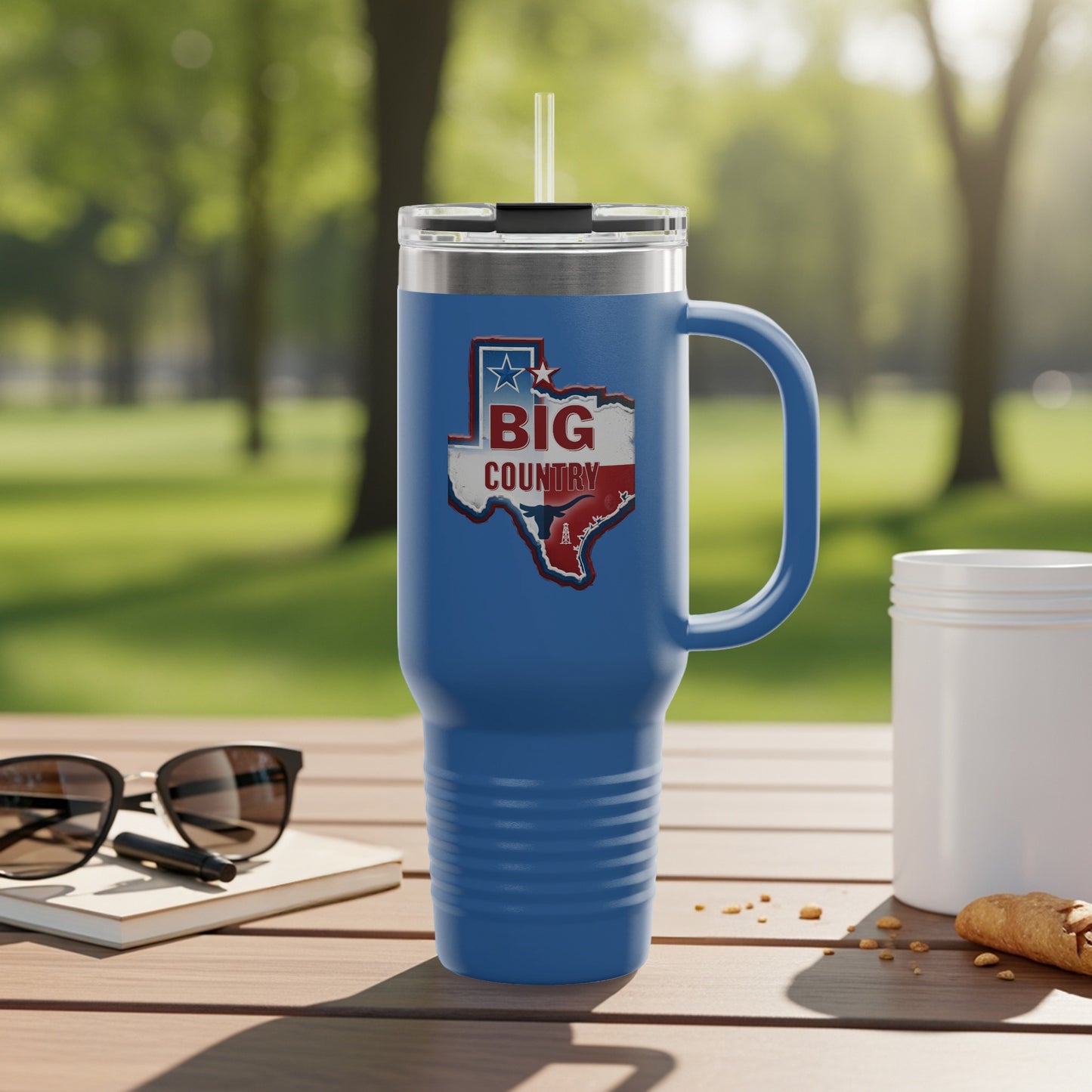 Blue tumbler with "Big Country" Texas map graphic and handle.