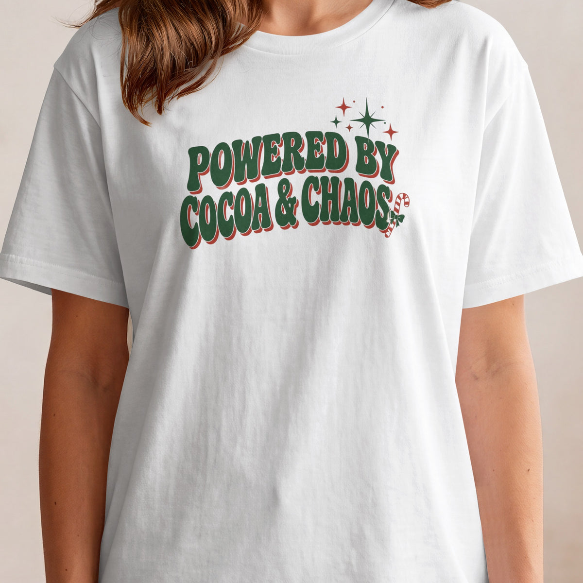 White t-shirt with "POWERED BY COCOA & CHAOS" graphic and candy cane.