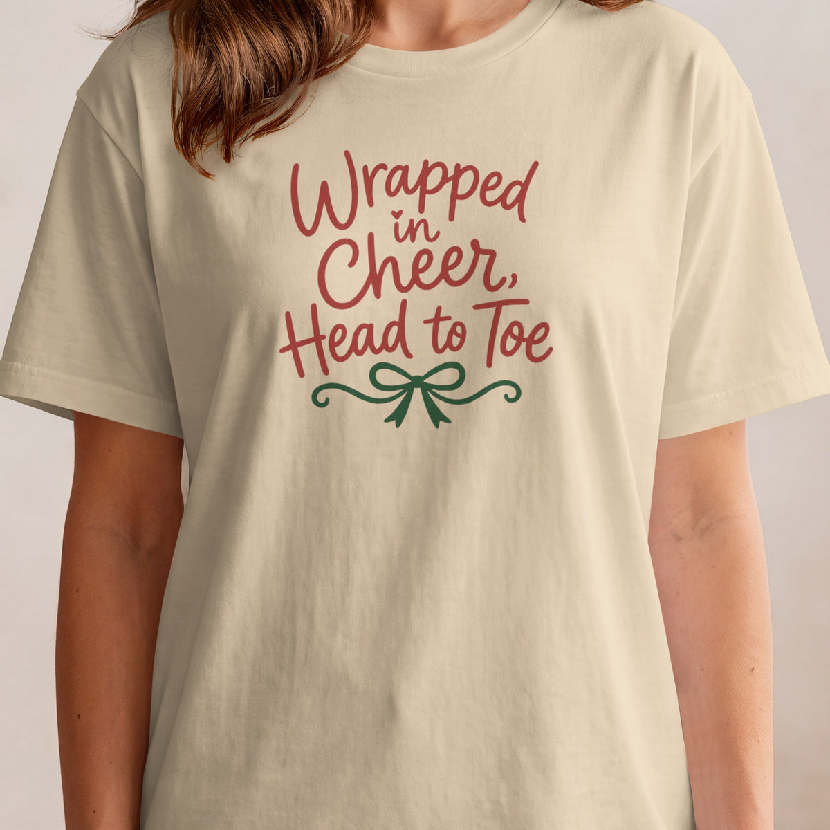 T-shirt with "Wrapped in Cheer, Head to Toe" text and a green bow.