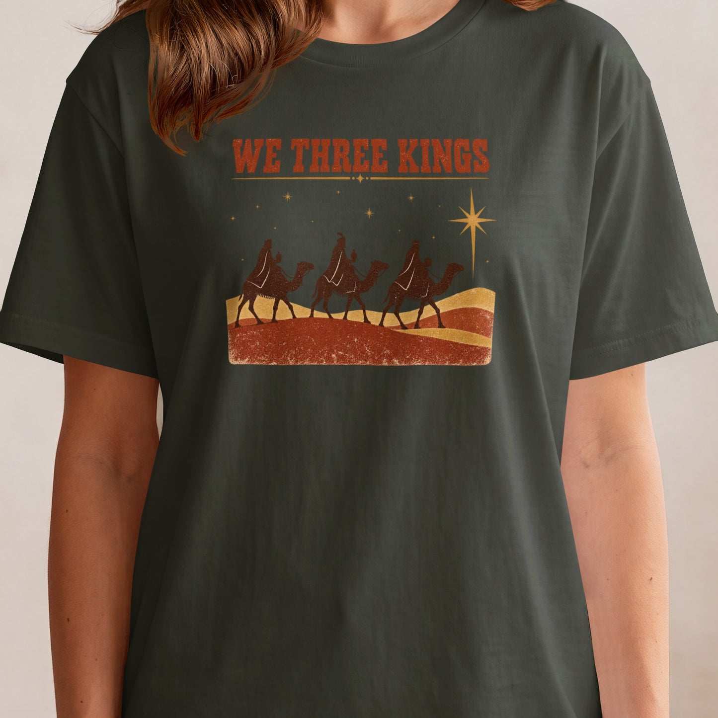 T-shirt with "We Three Kings" text and a vintage illustration of three camels and a star.