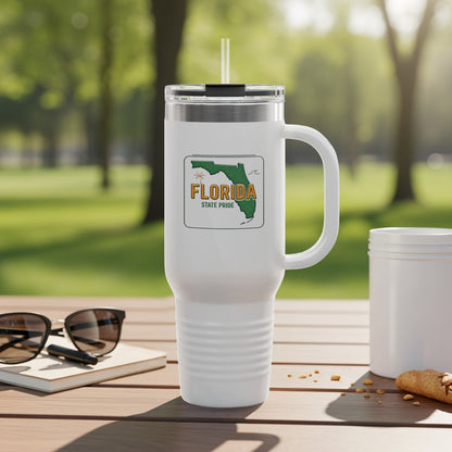 White tumbler with Florida State Pride logo and handle, on a table outdoors.