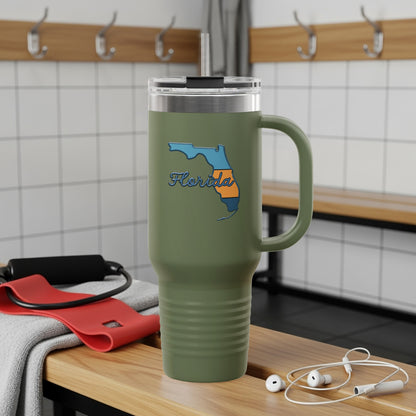 Green tumbler with Florida outline, red resistance band, and white earbuds on bench.