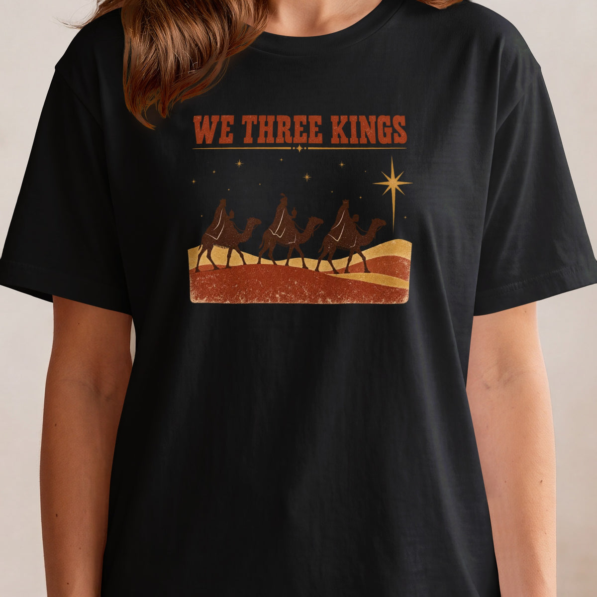 Black t-shirt with "WE THREE KINGS" text and three camels under a star.
