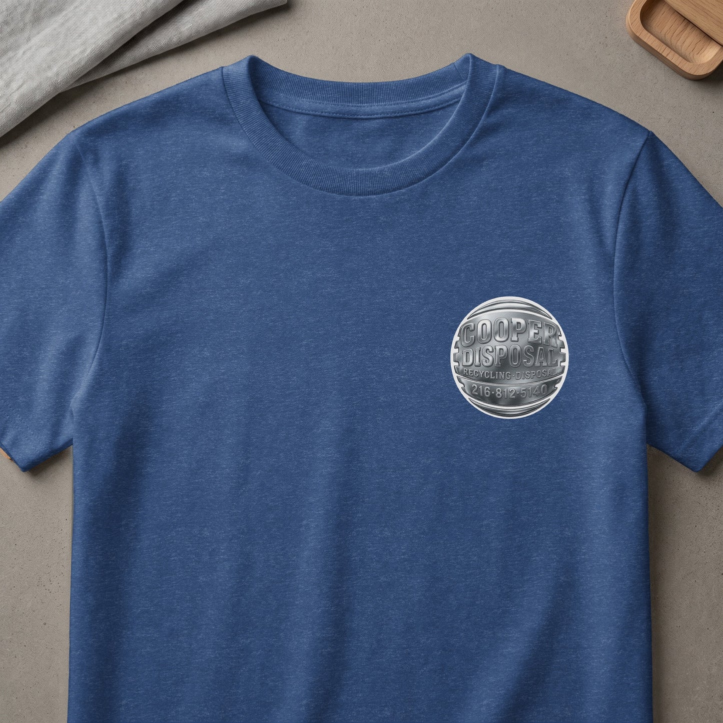 Blue t-shirt with a circular Cooper Disposal logo on the chest.