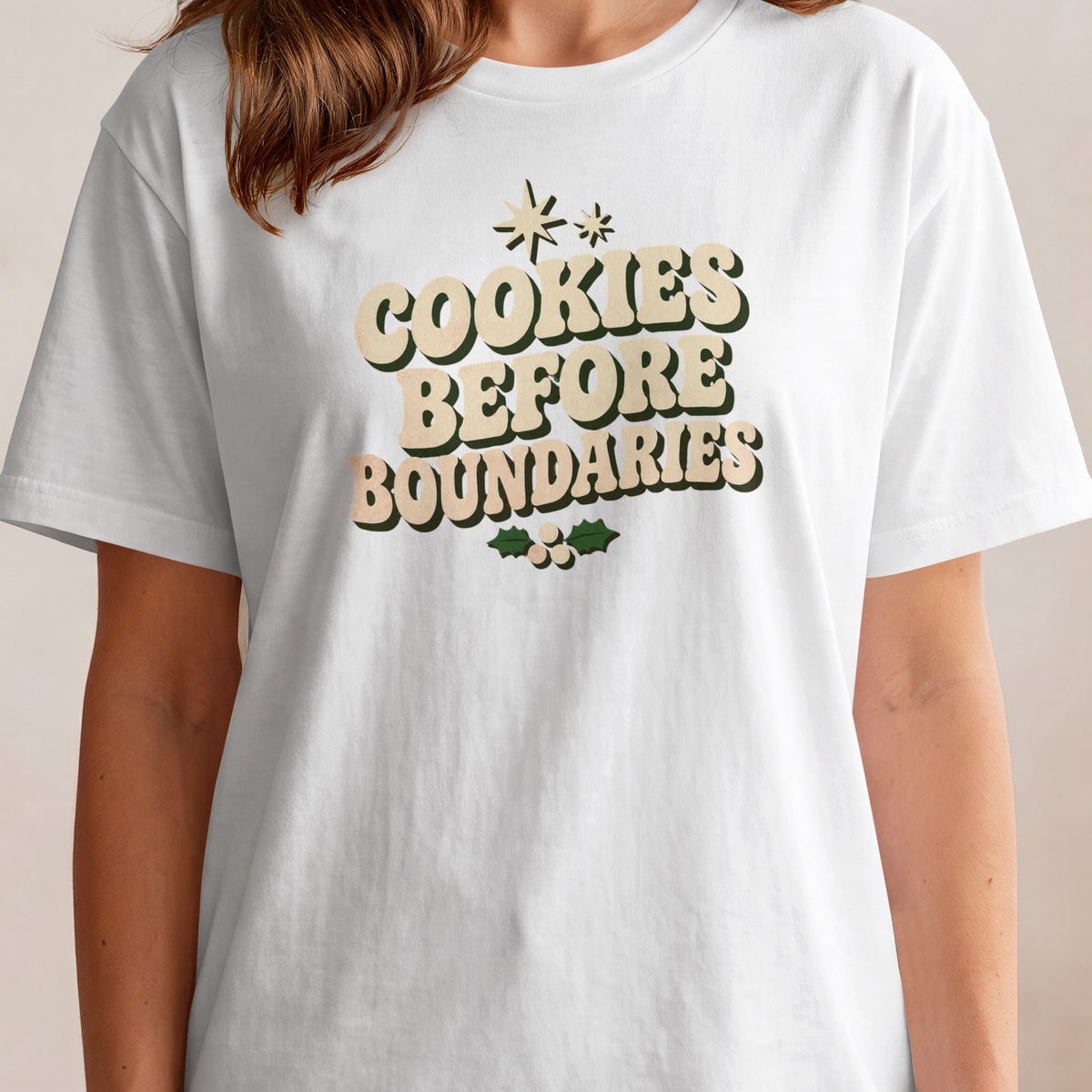 White t-shirt with "Cookies Before Boundaries" text and holly graphic.