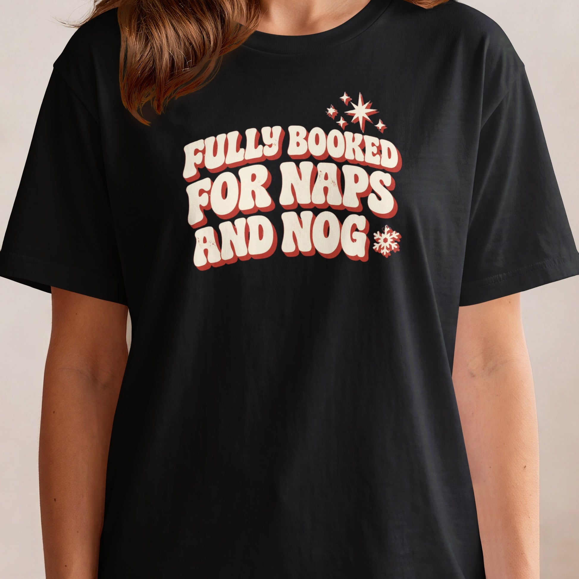 Black t-shirt with "FULLY BOOKED FOR NAPS AND NOG" text and festive holiday graphics.