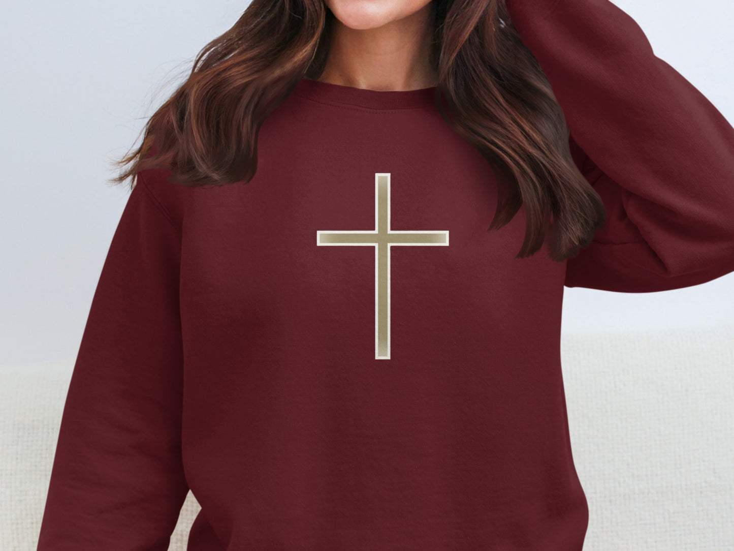 Maroon sweatshirt with a metallic silver cross graphic.