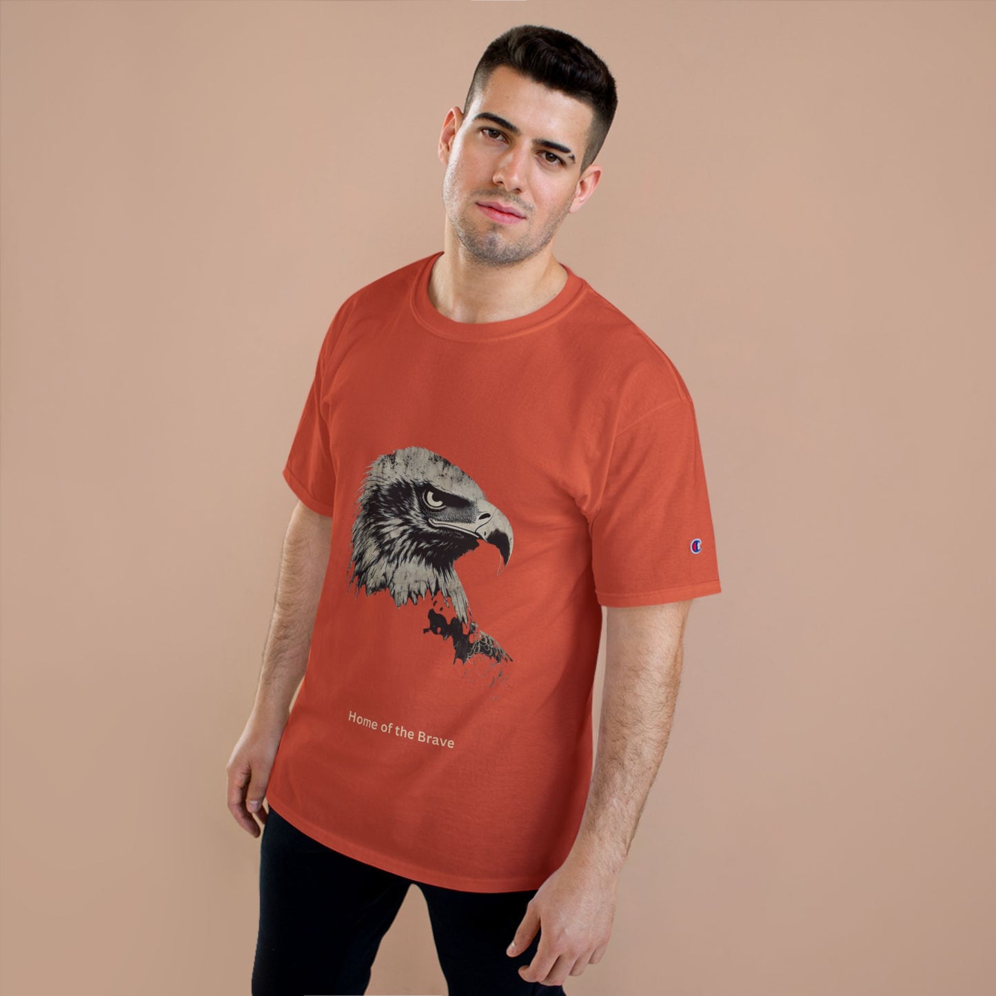 Home of the Brave small font text below an eagle head on a Champion Tee