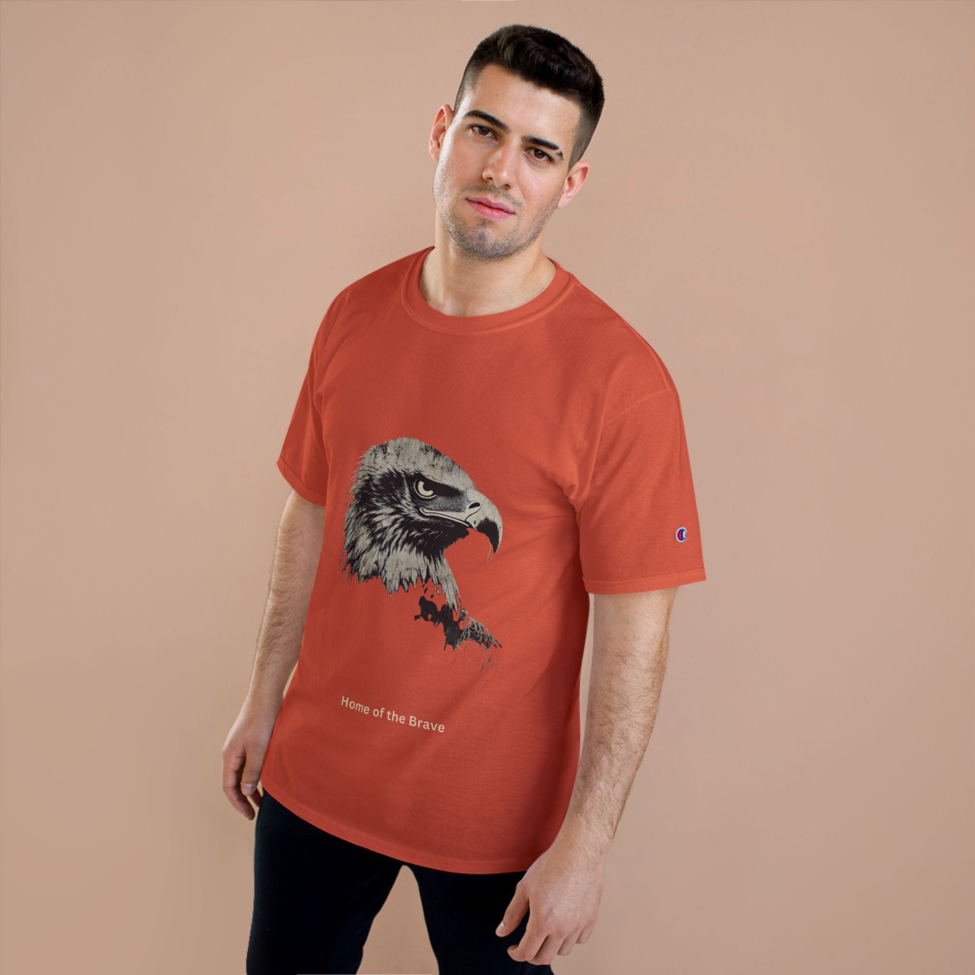 Home of the Brave small font text below an eagle head on a Champion Tee