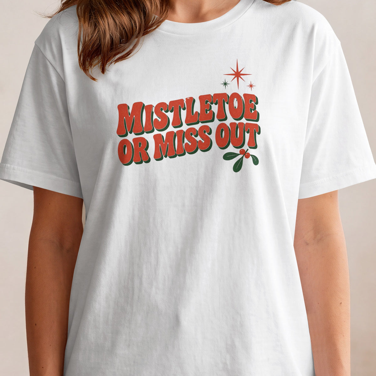 White t-shirt with "Mistletoe Or Miss Out" text and festive mistletoe graphic.