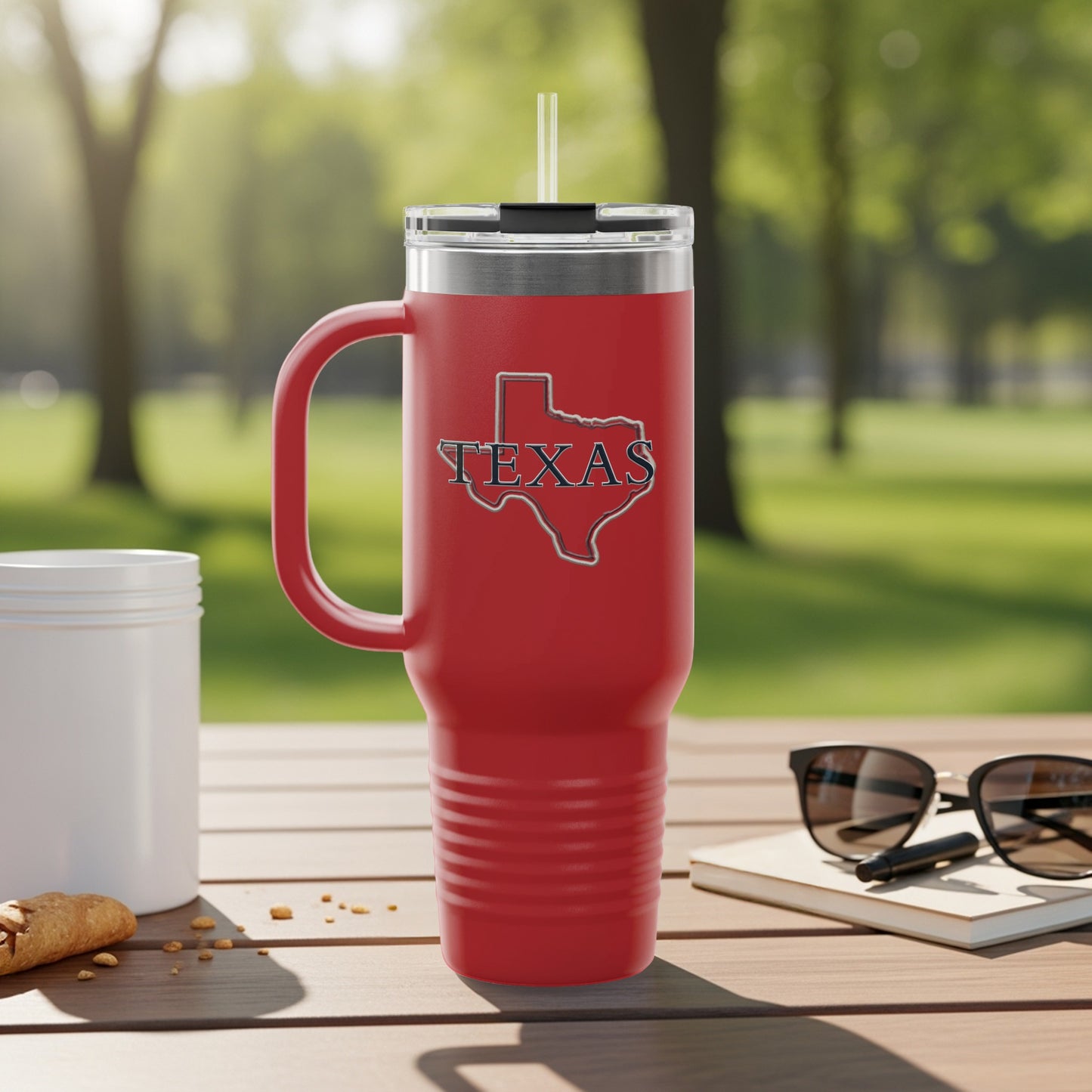 Red Texas tumbler with handle and straw on a table.