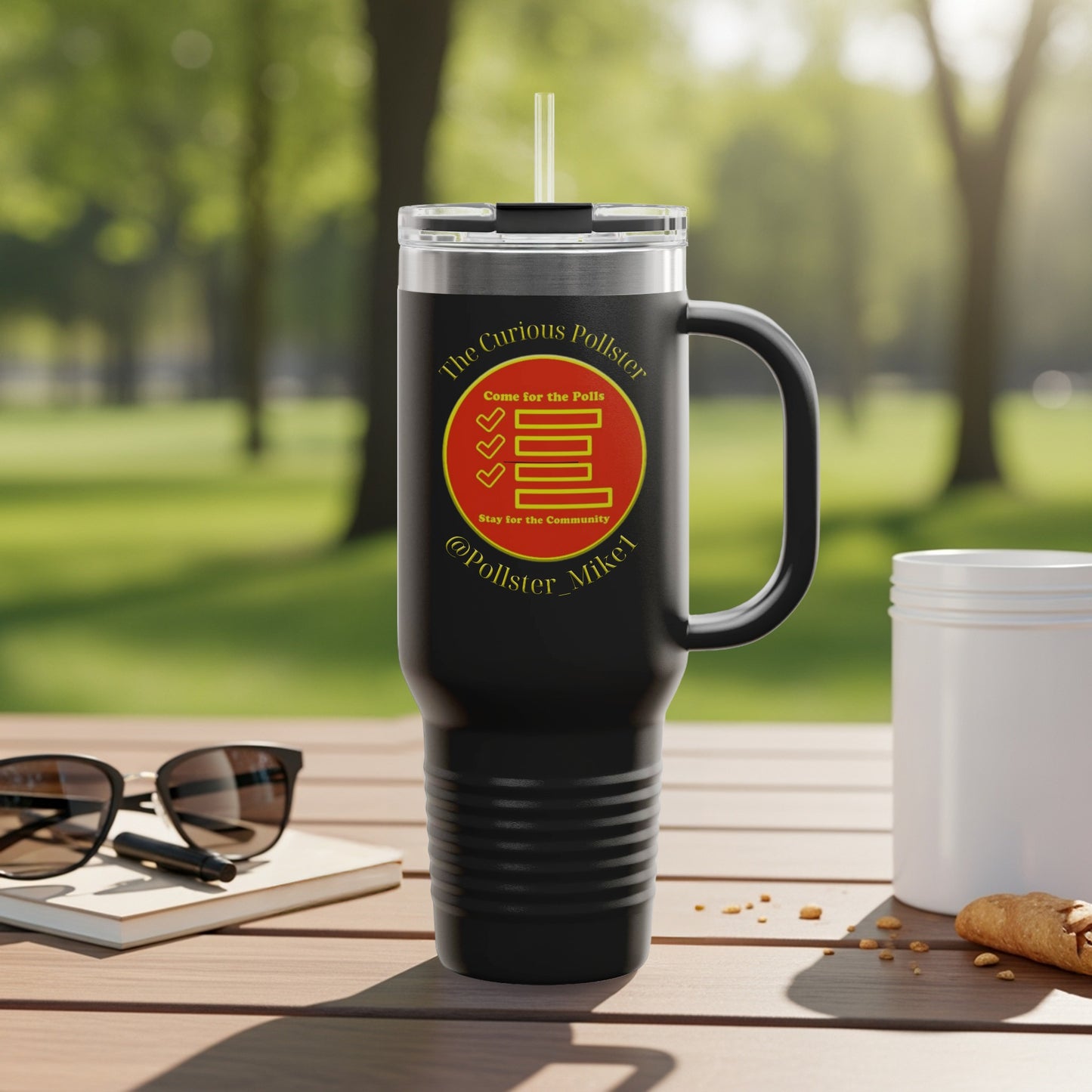 Black travel tumbler with "The Curious Pollster" logo and handle on a wooden table.