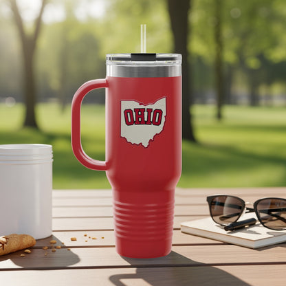 Red tumbler with Ohio outline logo and handle, on a table outdoors.