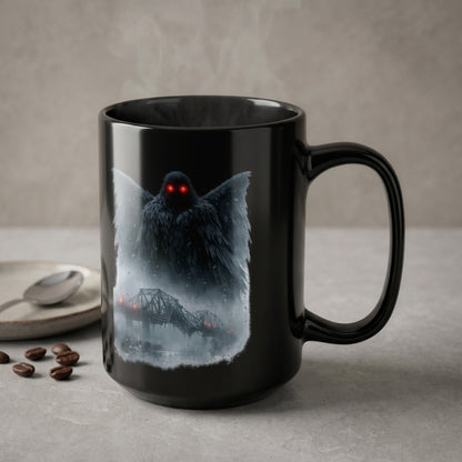 Black mug with mothman and a bridge illustration, steam rising.