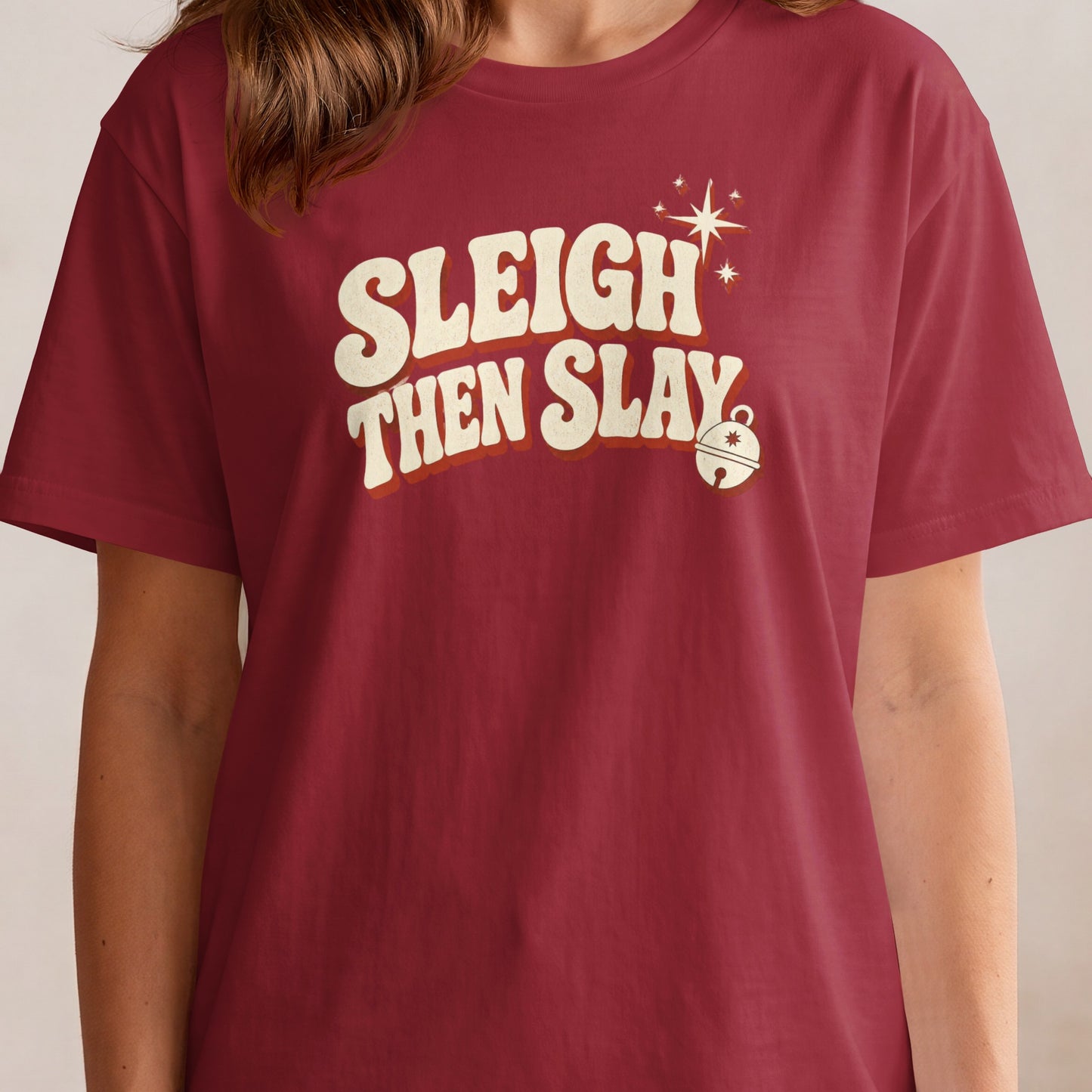 Burgundy t-shirt with "Sleigh Then Slay" text, stars, and a bell graphic.