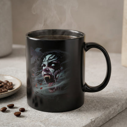 Black mug with a spooky vampire face design and steam rising from coffee.