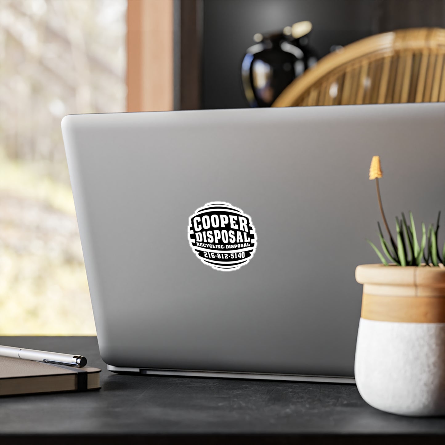 Black and white circular sticker on laptop: Cooper Disposal Recycling Disposal 218-812-5140.