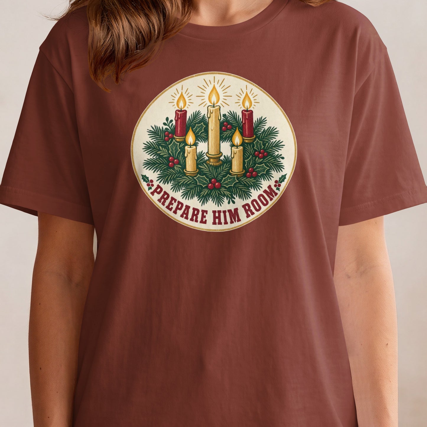 T-shirt with a circular graphic of lit candles, holly, and pine branches with text.