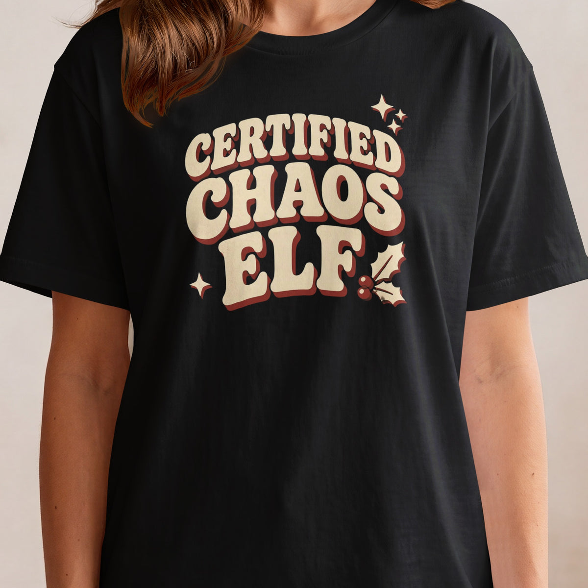Black t-shirt with "Certified Chaos Elf" text and holiday accents.