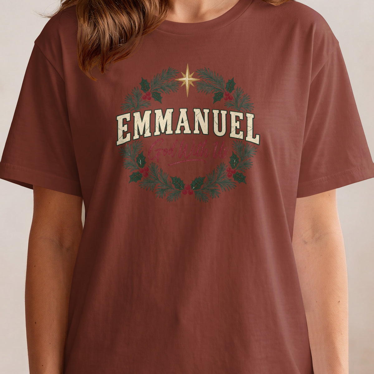 Brown t-shirt with a Christmas wreath graphic and text "EMMANUEL God With Us".